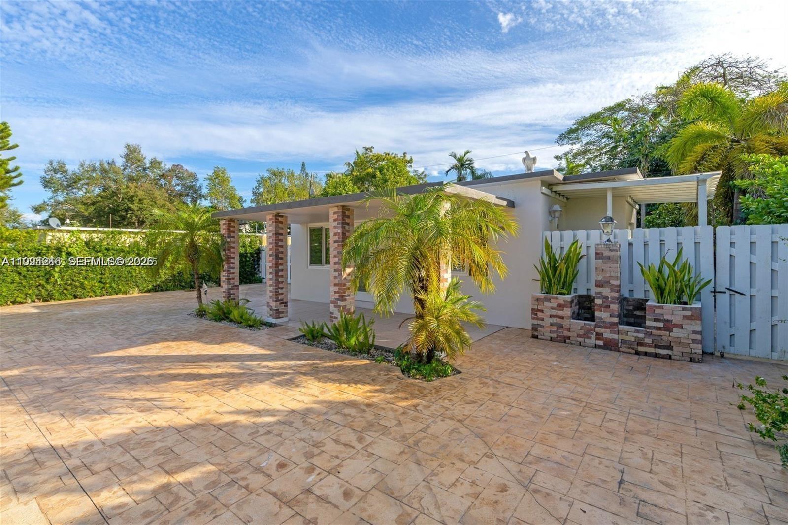 3800 Charles Terrace Miami, FL 33133 - Photo 3 of 16 a backyard with potted plants and a large tree