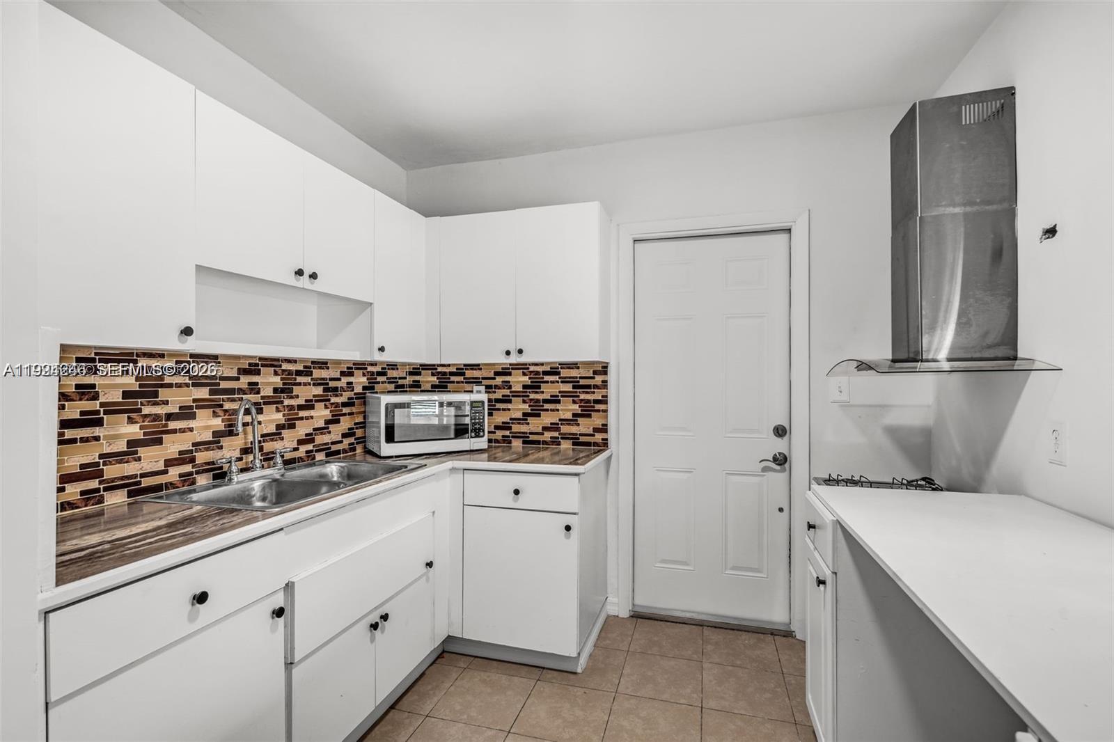 3800 Charles Terrace Miami, FL 33133 - Photo 8 of 16 a kitchen with granite countertop a sink and cabinets