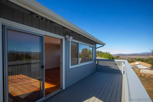 a view of balcony with wooden floor and seating space