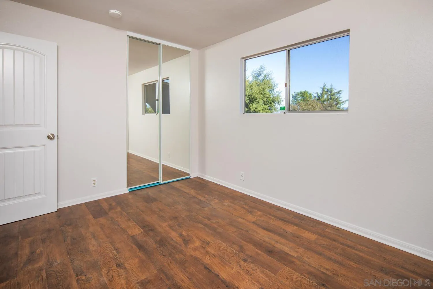 18435 Chablis Road Ramona, CA 92065 - Photo 27 of 49 a view of an empty room with wooden floor and a window