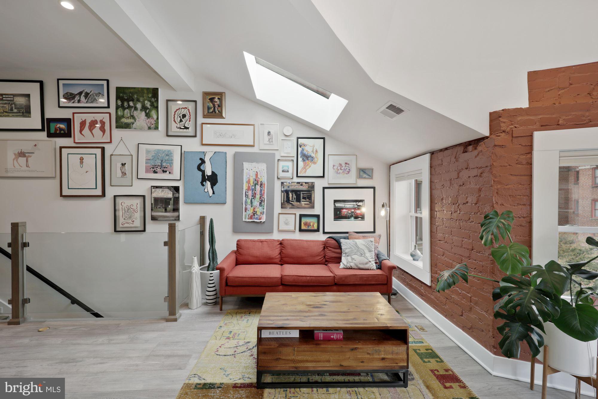 a living room with furniture hardwood floor and a potted plant