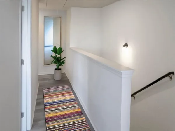 a view of a hallway with wooden floor and a potted plant