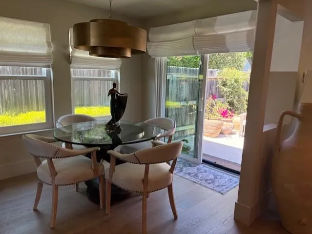 a view of a dining room with furniture a chandelier and wooden floor