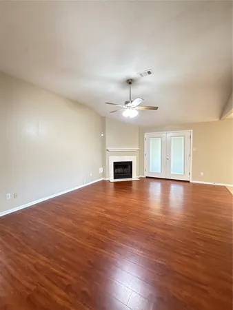 a view of empty room with wooden floor and fireplace