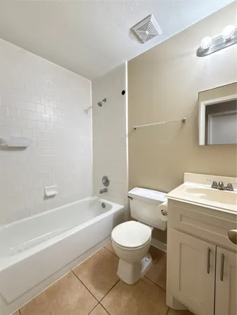 a bathroom with a toilet a sink a mirror and bathtub