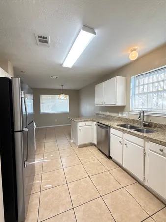 a kitchen with a sink a refrigerator and cabinets