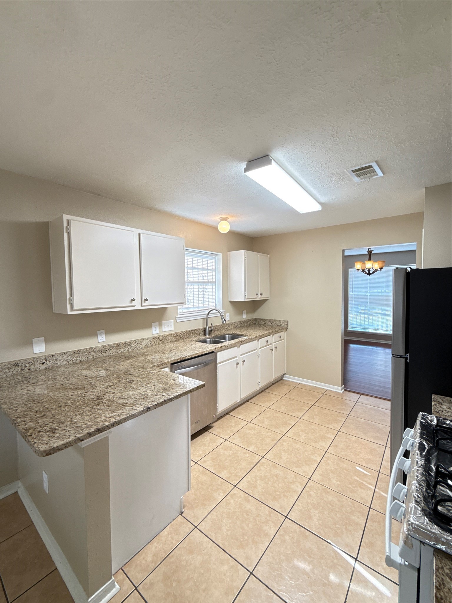 15919 Hiram Clarke Road Houston, TX 77053 - Photo 10 of 29 a kitchen with stainless steel appliances granite countertop a stove a sink and a refrigerator