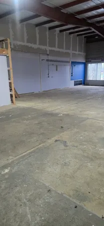 a view of empty room with a fireplace and kitchen view