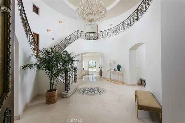 a view of hall way with furniture and chandelier
