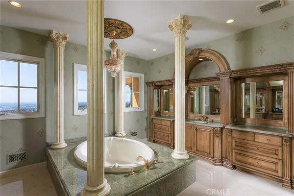 a bathroom with a granite countertop tub and a window