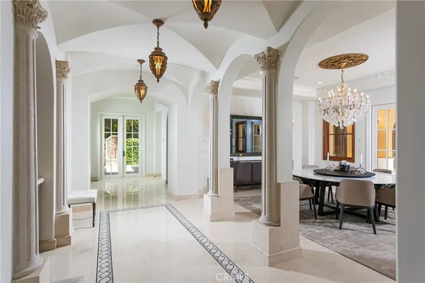 a view of a livingroom and a dining room with chandelier fan