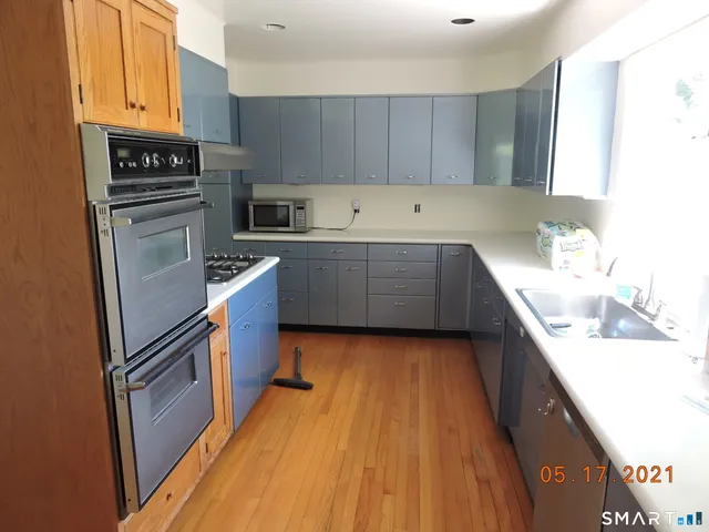 a kitchen with wooden floors and stainless steel appliances