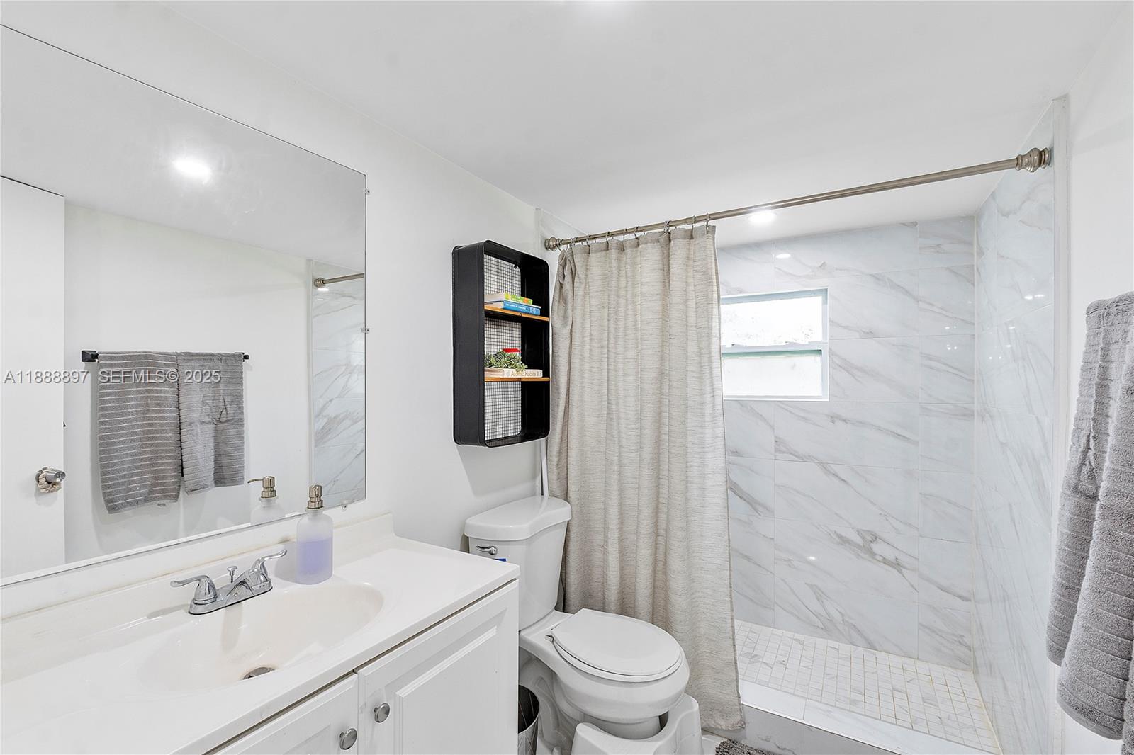 1101 Northwest 40th Street Miami, FL 33127 - Photo 13 of 31 a bathroom with a sink toilet a mirror and shower