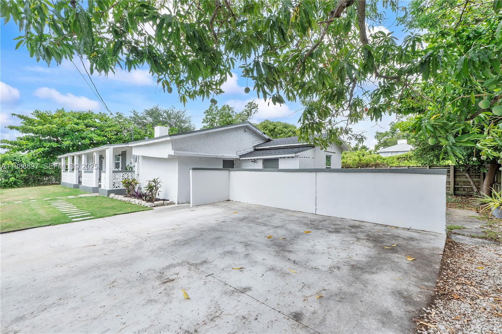 1101 Northwest 40th Street Miami, FL 33127 - Photo 23 of 31 a view of a house with a yard and large tree