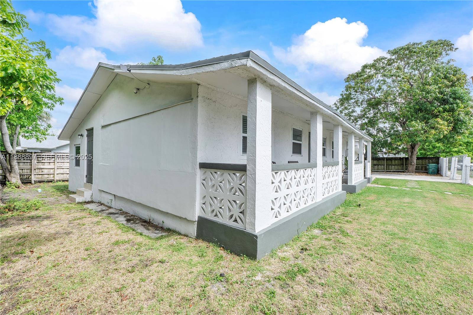 1101 Northwest 40th Street Miami, FL 33127 - Photo 25 of 31 a view of a house with a small yard and wooden fence