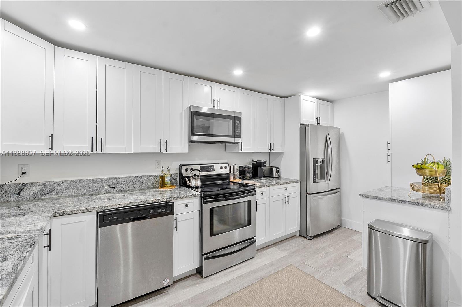 1101 Northwest 40th Street Miami, FL 33127 - Photo 4 of 31 a kitchen with stainless steel appliances granite countertop a stove a sink and a refrigerator
