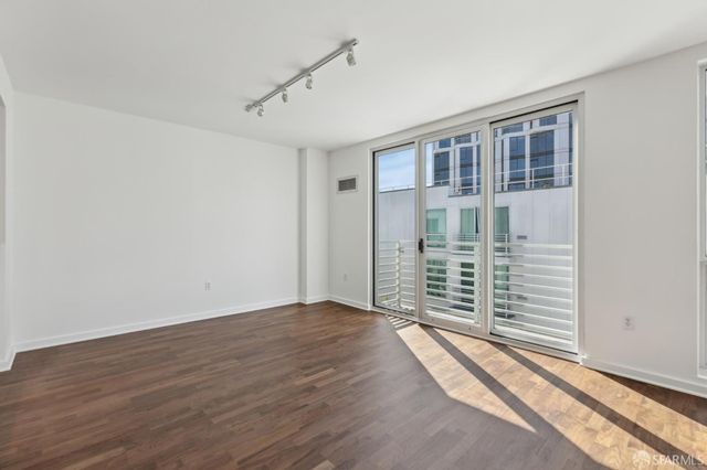 a view of an empty room with wooden floor