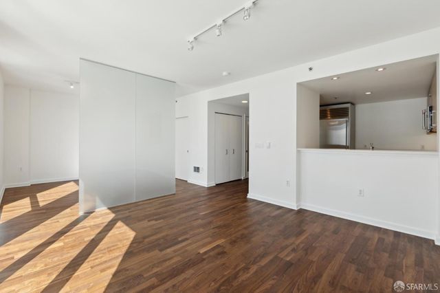 a view of empty room with wooden floor