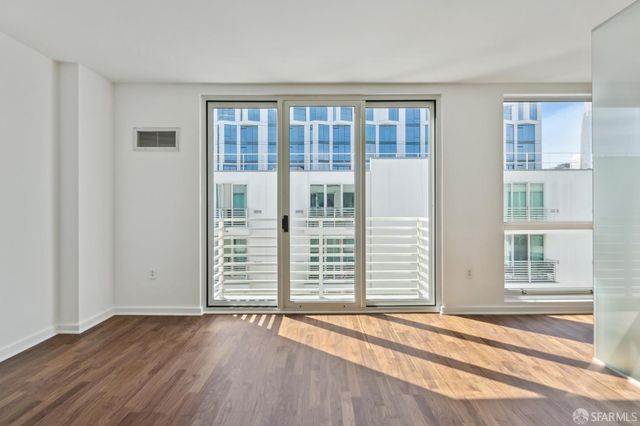 a view of a big room with wooden floor and windows