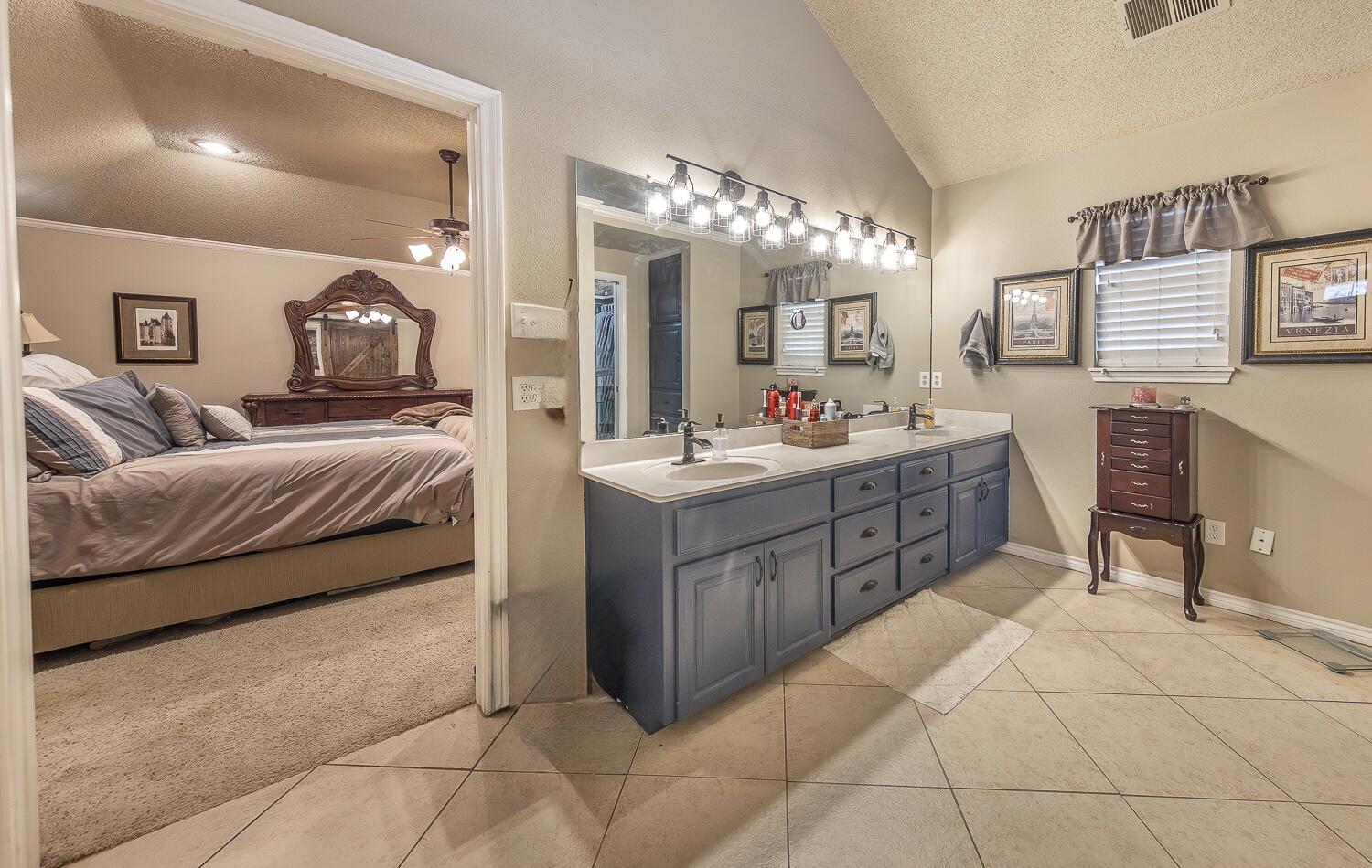 6309 County Road 7470 Lubbock, TX 79424 - Photo 19 of 41 a en suite bathroom with a double vanity sink and a mirror