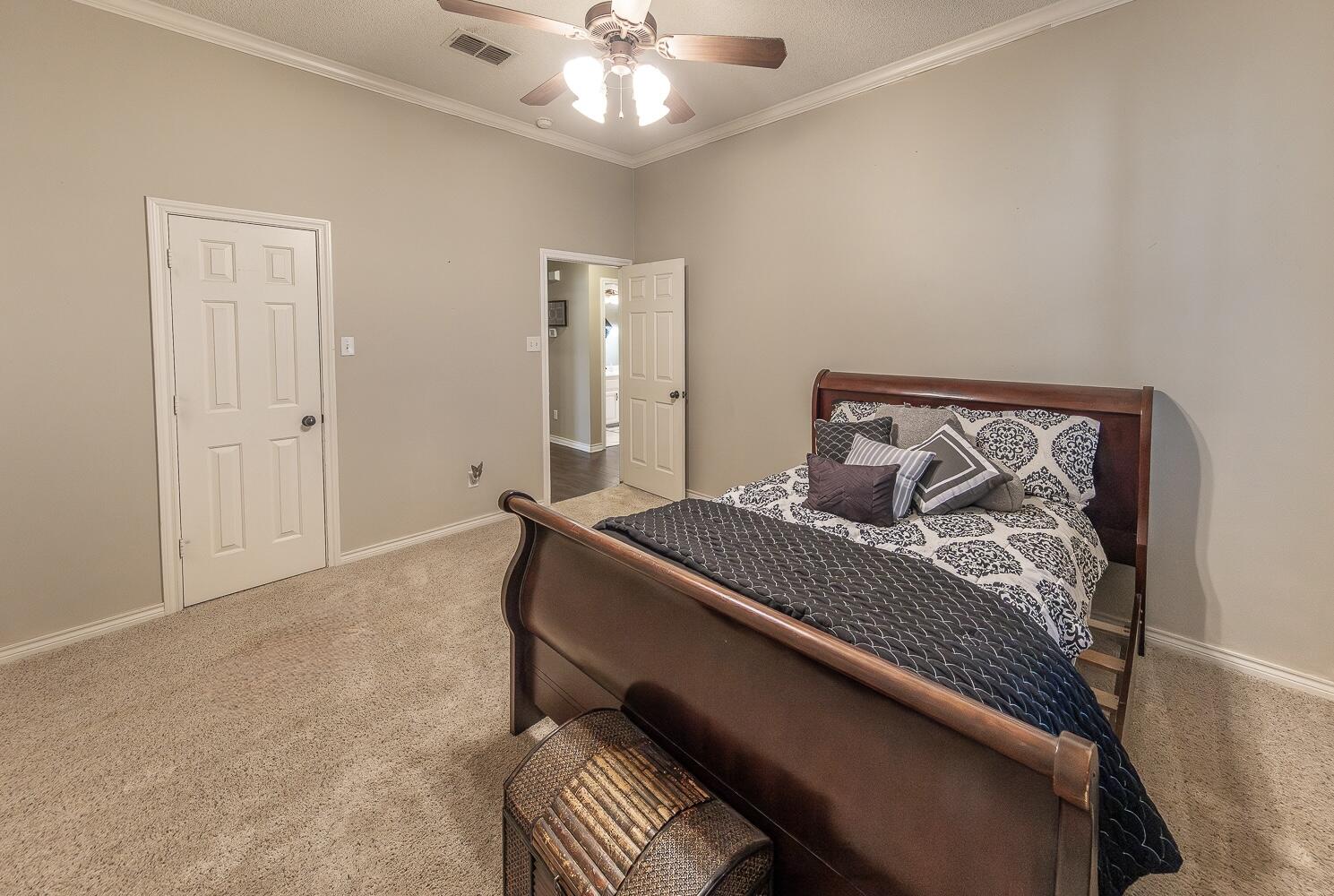 6309 County Road 7470 Lubbock, TX 79424 - Photo 21 of 41 a bedroom with a bed and a chandelier
