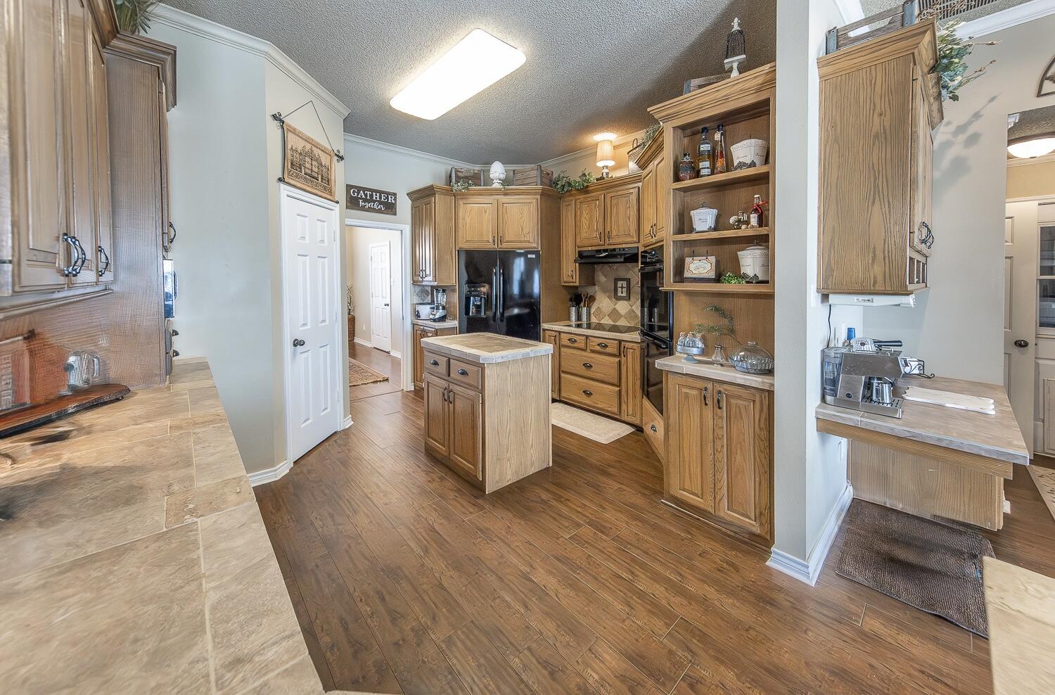 6309 County Road 7470 Lubbock, TX 79424 - Photo 7 of 41 a kitchen with cabinets and wooden floor