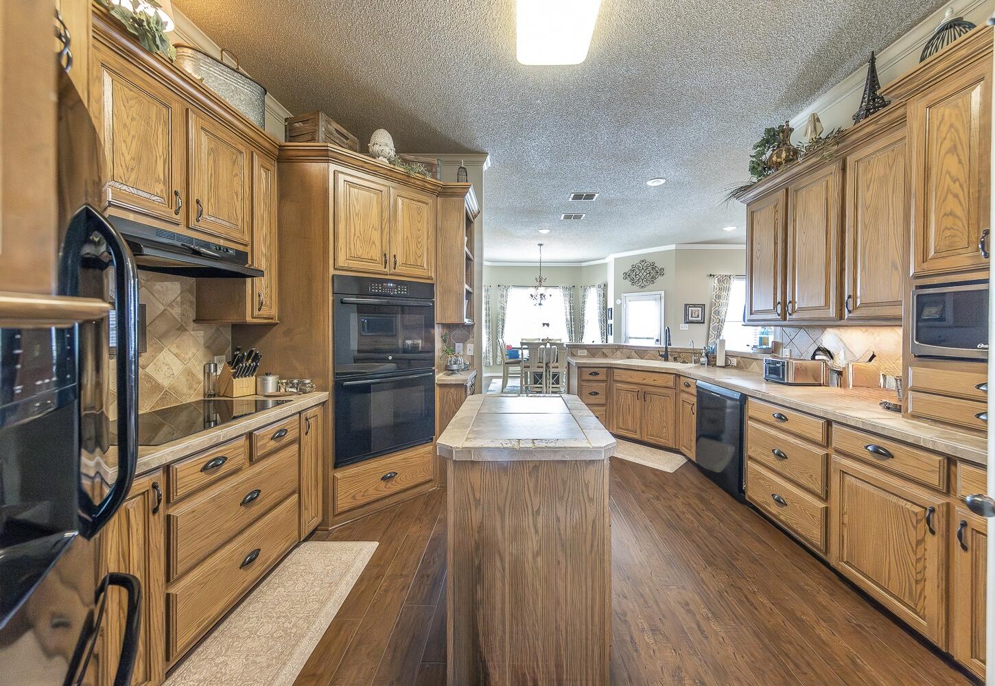 6309 County Road 7470 Lubbock, TX 79424 - Photo 8 of 41 a large kitchen with stainless steel appliances granite countertop a lot of counter space and wooden floors