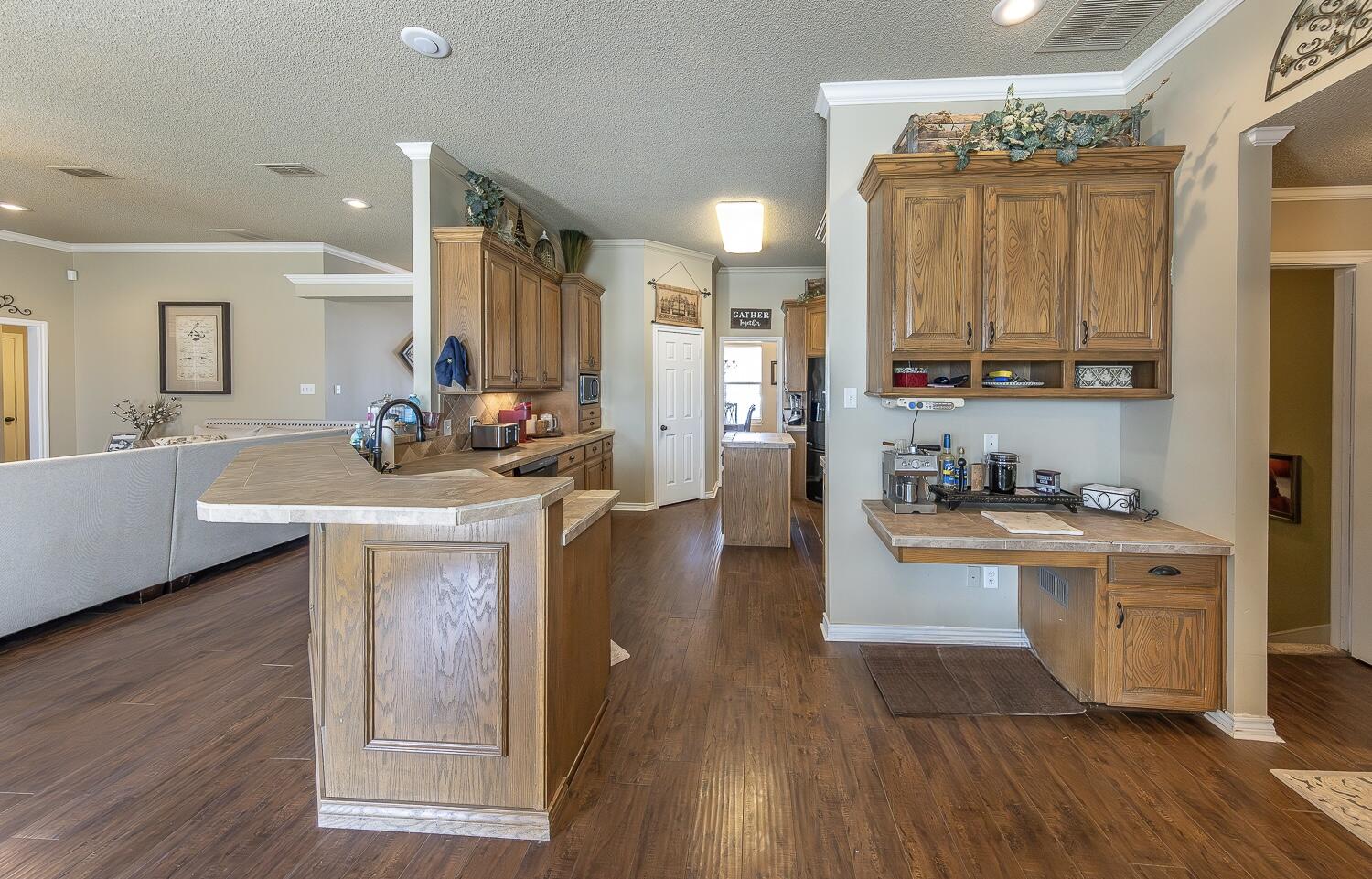 6309 County Road 7470 Lubbock, TX 79424 - Photo 9 of 41 a kitchen with stainless steel appliances a sink a stove a refrigerator cabinets and wooden floor