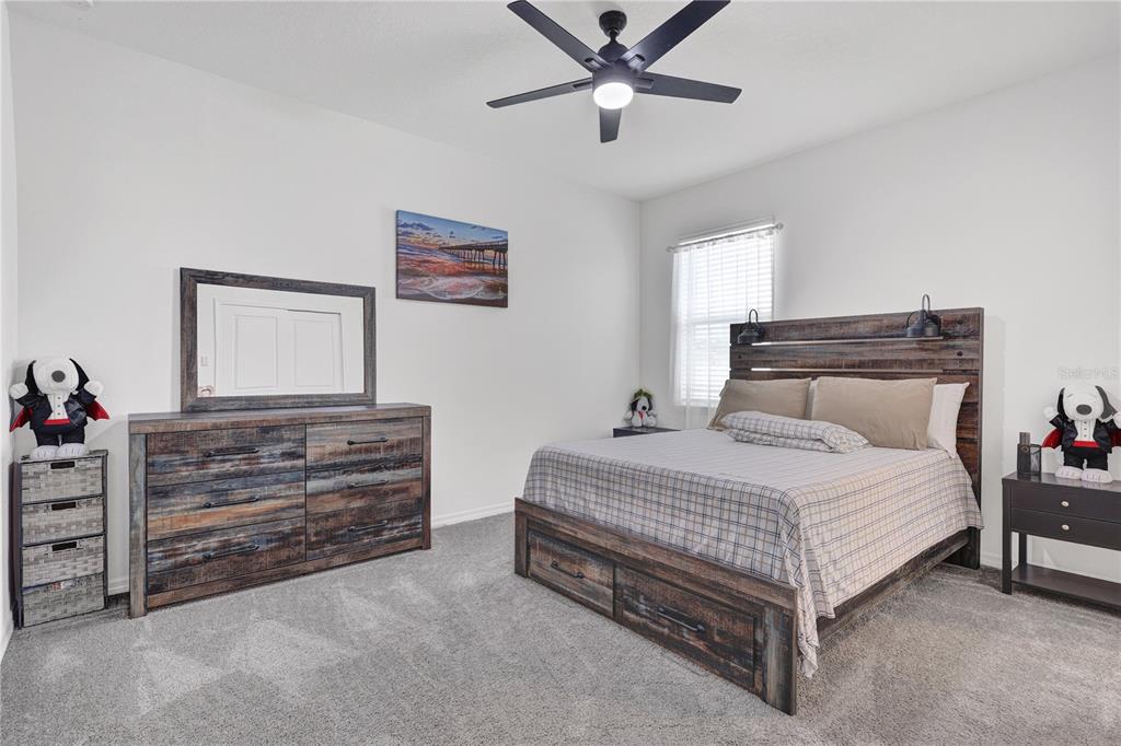 7185 Southwest 63rd Street Ocala, FL 34474 - Photo 23 of 31 a bedroom with a bed and a chandelier
