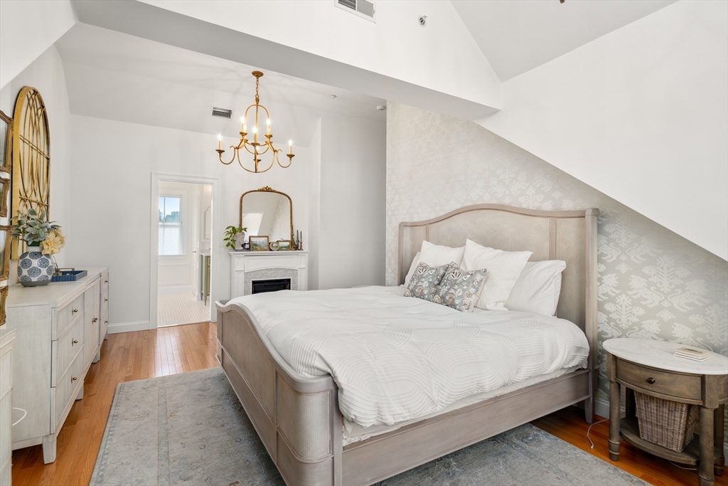 19 Charles Street Boston, MA 02129 - Photo 11 of 28 a bedroom with a bed and a chandelier