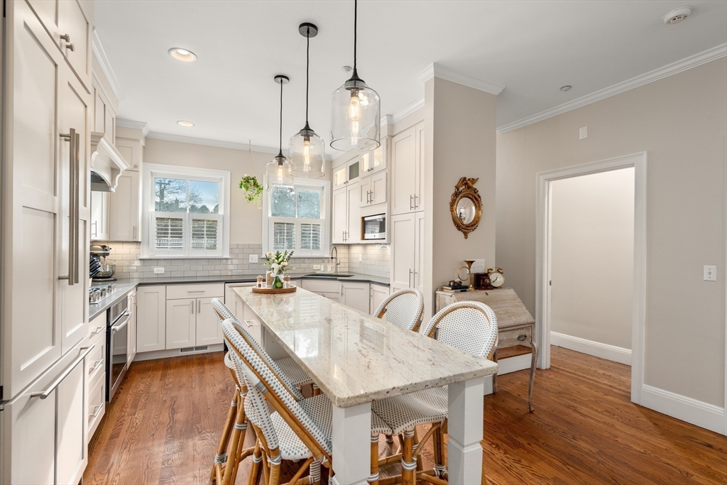 19 Charles Street Boston, MA 02129 - Photo 3 of 28 a large kitchen with granite countertop a stove a sink a dining table and chairs