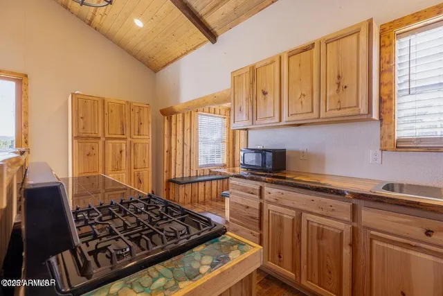 a kitchen with wooden cabinets and a stove top oven