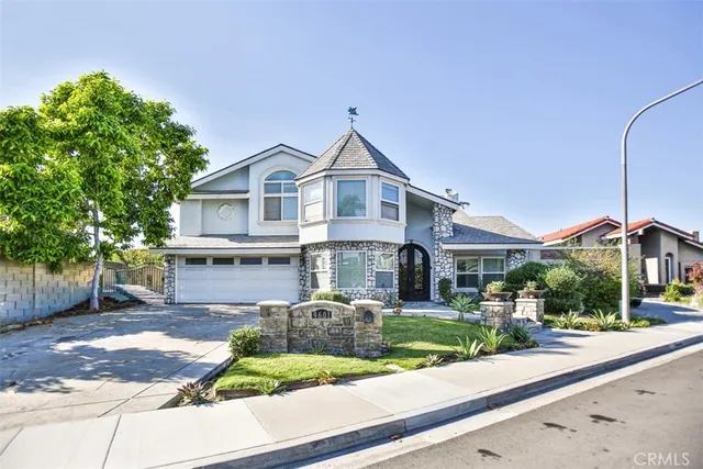 a front view of a house with a yard and potted plants