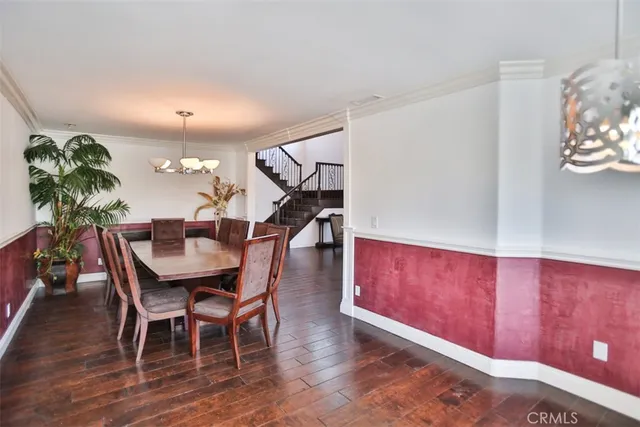 a dining room with furniture a chandelier and wooden floor