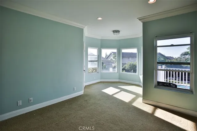 a bed sitting in a spacious bedroom next to a window