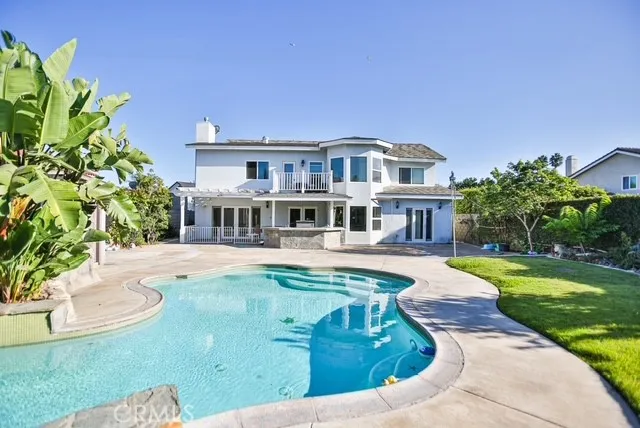 a view of a swimming pool with a yard and palm trees