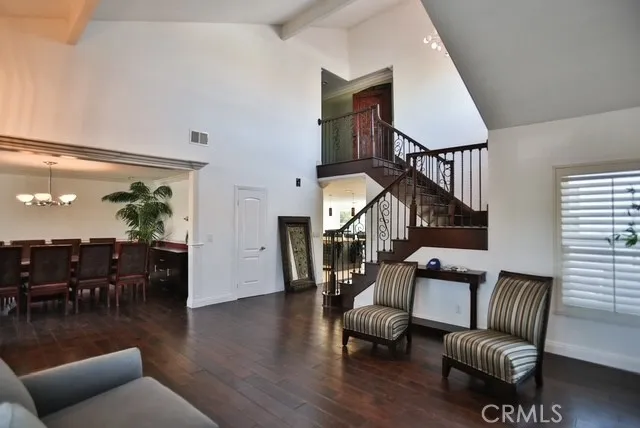 a living room with furniture kitchen view and a wooden floor