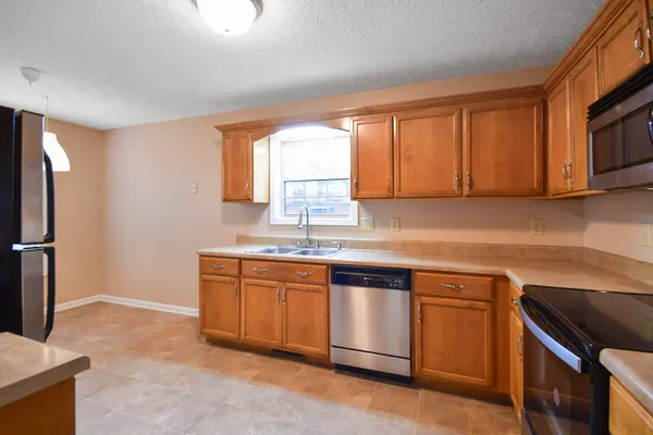 a kitchen with stainless steel appliances granite countertop a sink stove and refrigerator