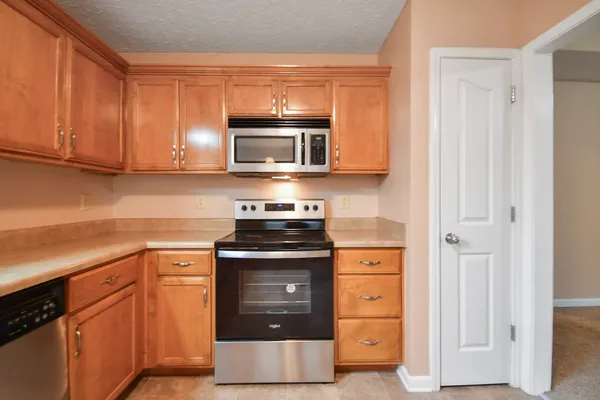 a kitchen with cabinets stainless steel appliances and wooden cabinets