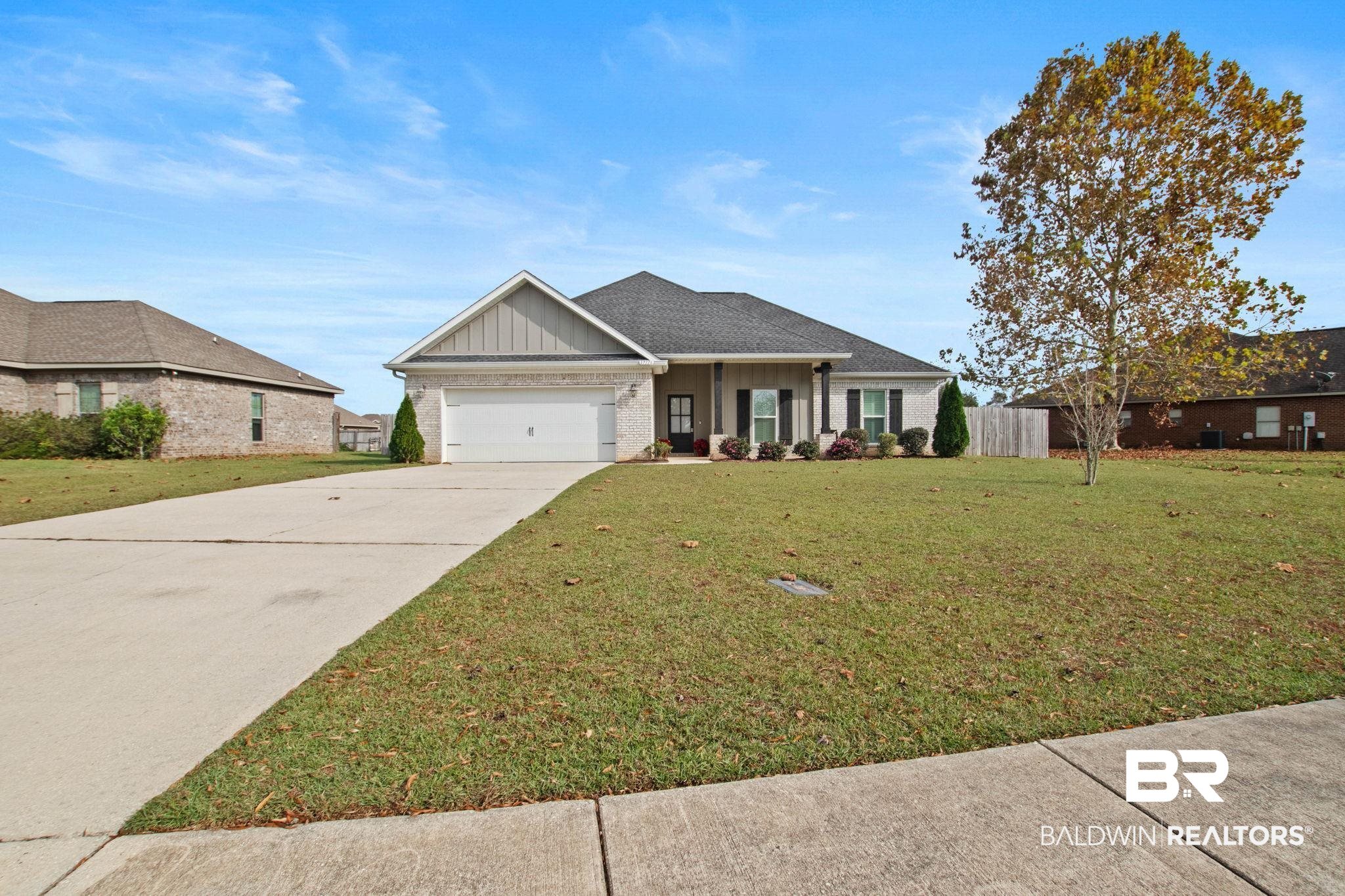 17376 Bankhead Boulevard Fairhope, AL 36532 - Photo 2 of 73 View of front of house with board and batten siding, a porch, driveway, brick siding, and a garage