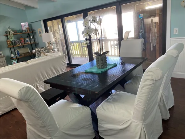 a view of a dining room with furniture a chandelier and wooden floor