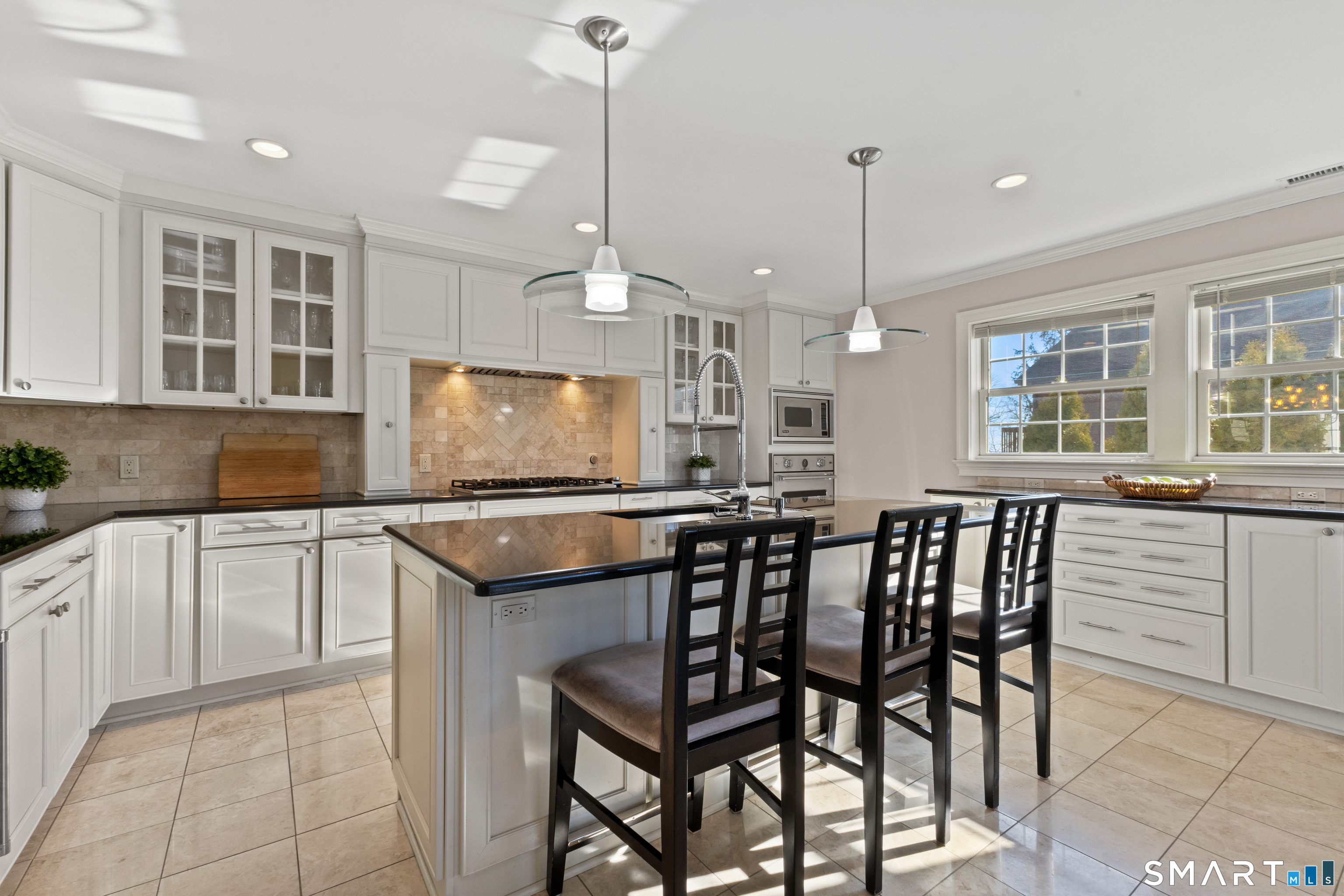 61 Hobson Street Stamford, CT 06902 - Photo 13 of 36 a kitchen with kitchen island granite countertop a table chairs sink and microwave