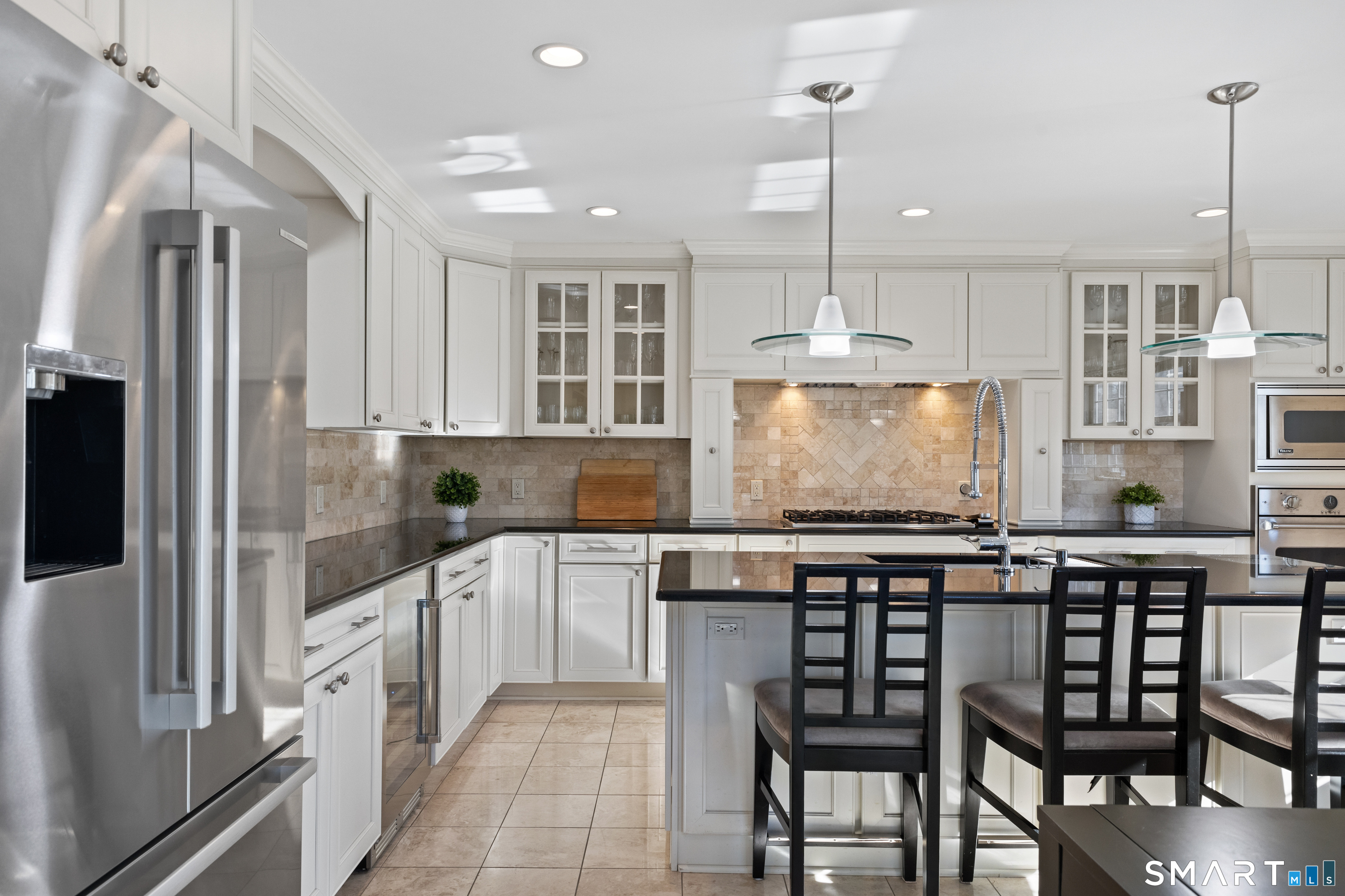 61 Hobson Street Stamford, CT 06902 - Photo 14 of 36 a kitchen with stainless steel appliances granite countertop a stove top oven a refrigerator a sink and chairs