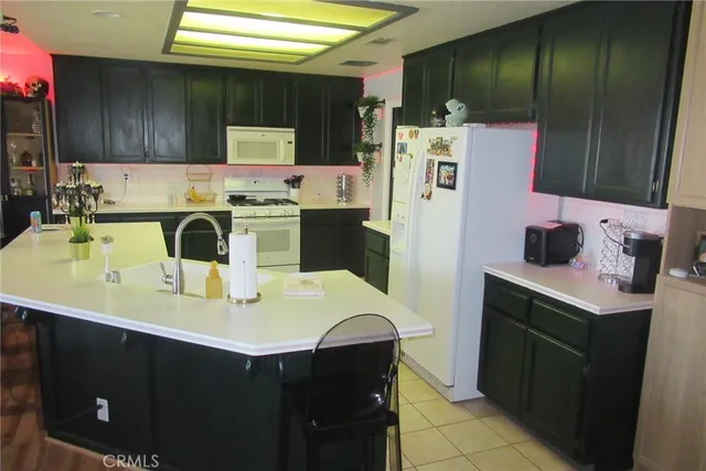 a kitchen with a sink a refrigerator and cabinets