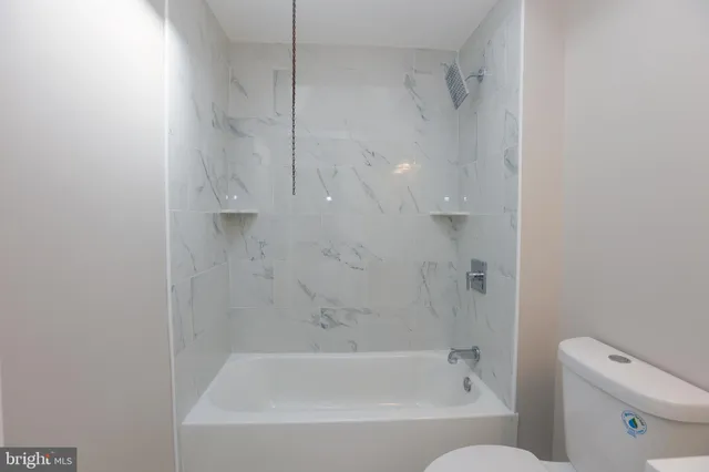 a bath room with a toilet and a bath tub