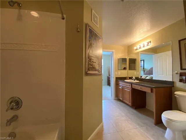 a large kitchen with stainless steel appliances granite countertop a refrigerator and a stove