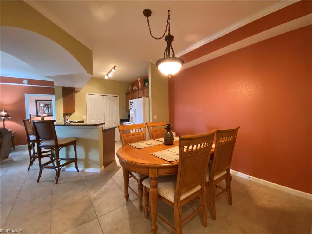 12940 Positano Circle, Unit 204 Naples, FL 34105 - Photo 4 of 39 a view of a dining room with furniture