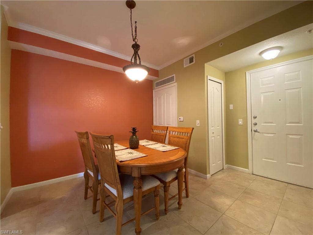 12940 Positano Circle, Unit 204 Naples, FL 34105 - Photo 5 of 39 a view of a dining room with furniture and chandelier