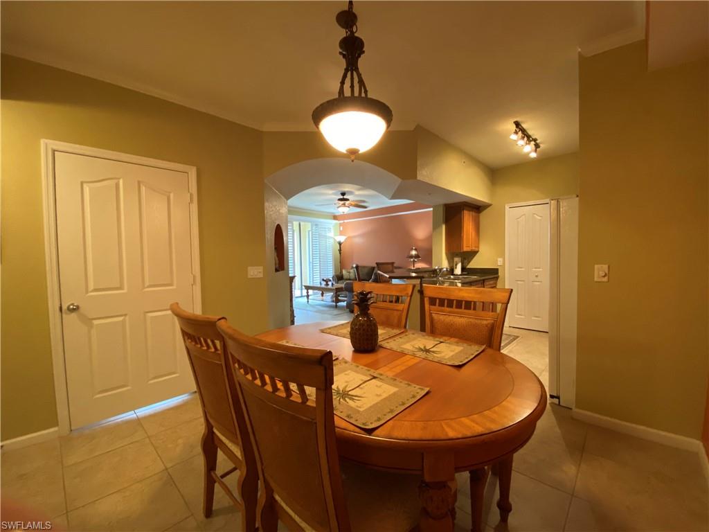 12940 Positano Circle, Unit 204 Naples, FL 34105 - Photo 6 of 39 a view of a dining room with furniture and chandelier
