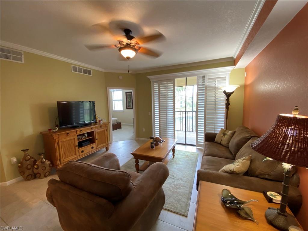 12940 Positano Circle, Unit 204 Naples, FL 34105 - Photo 8 of 39 a living room with furniture and a flat screen tv